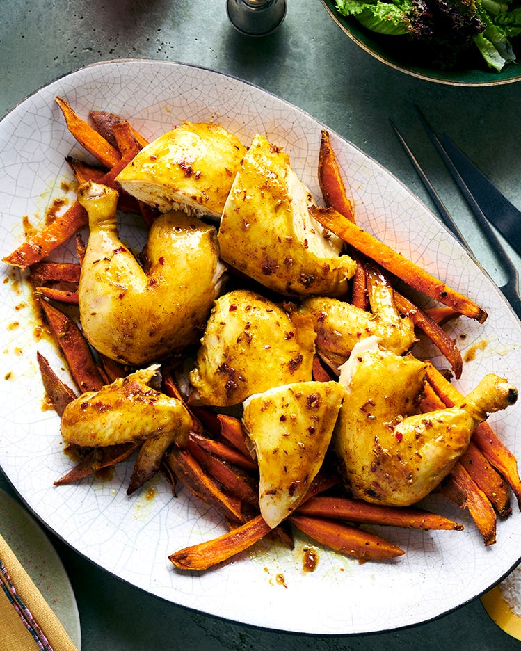 Spicy Maple Roasted Chicken With Sweet Potato Oven Fries Spicy maple-roasted chicken pieces served with sweet potato oven fries on a large platter.